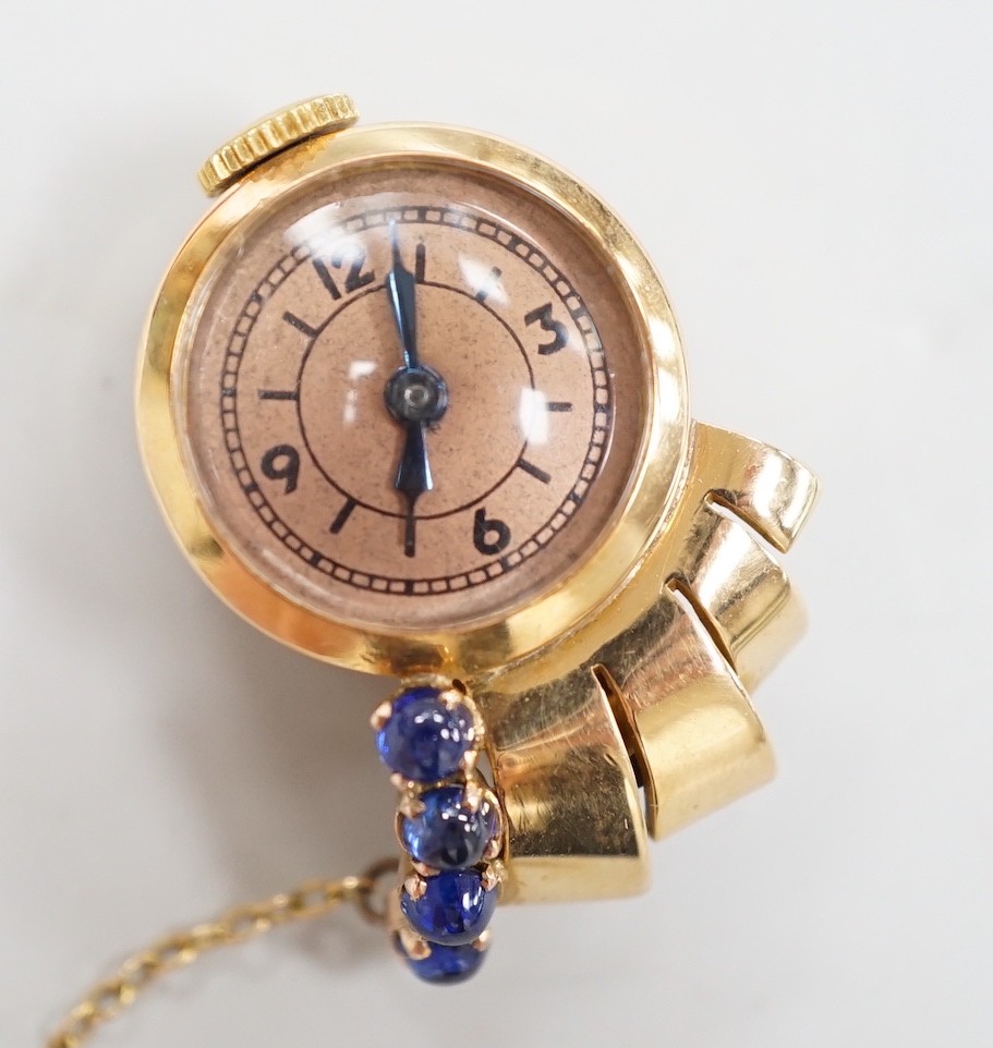 A lady's 1930's/1940's yellow metal and blue cabochon set lapel clip watch, 25mm, gross weight 9.5 grams, with a Richard Ogden gilt tooled leather box.
